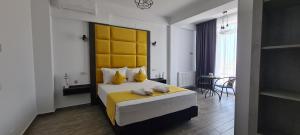 a bedroom with a large bed with a yellow headboard at YAMADA in Năvodari