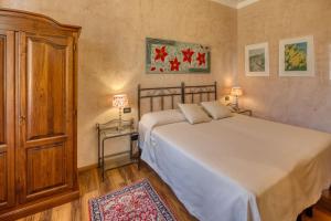 a bedroom with a large white bed and two lamps at Locanda Villa Moderna in Genoa