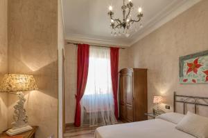a bedroom with a bed and a window with red curtains at Locanda Villa Moderna in Genoa