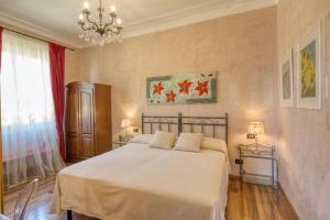 a bedroom with a large white bed and a chandelier at Locanda Villa Moderna in Genoa
