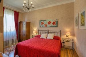a bedroom with a red bed and a chandelier at Locanda Villa Moderna in Genoa