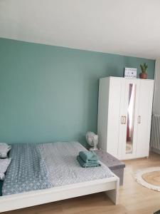 a bedroom with a bed and a white cabinet at Le Cosy du Faux Bourg in Châlons-sur-Marne