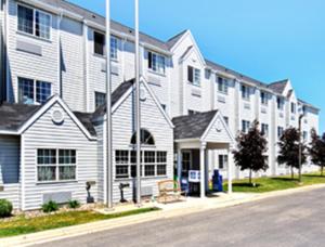 duży biały budynek po stronie ulicy w obiekcie Microtel Inn & Suites by Wyndham Rochester North Mayo Clinic w mieście Rochester