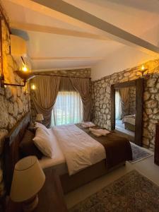 a bedroom with a large bed and a stone wall at Kalabantia House in Fethiye