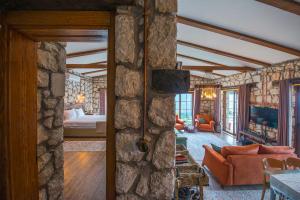 a living room with a stone wall and a bedroom at Kalabantia House in Fethiye