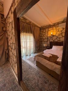 a bedroom with a bed and a stone wall at Kalabantia House in Fethiye