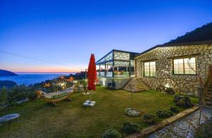 a house with a bench and a hammock in the yard at Kalabantia House in Fethiye