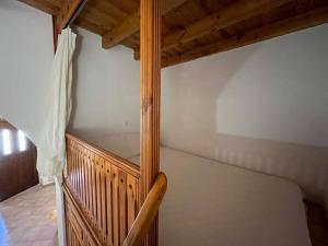 a wooden staircase in a room with a bed at Kostas Village House in Psinthos +2 photos