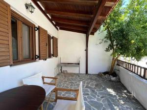a porch of a house with a table and chairs at Kostas Village House in Psinthos