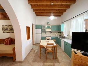 a kitchen with green cabinets and a table with a dining room at Kostas Village House in Psinthos