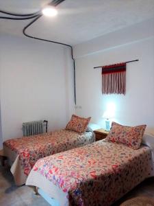 a bedroom with two beds and a window and a lamp at Hotel Medina B&B in Mar del Plata