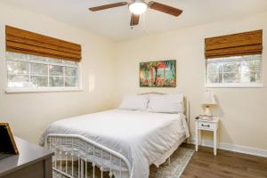 a white bedroom with a bed and a ceiling fan at The Green Bench Cottage - Pet Friendly in St Petersburg