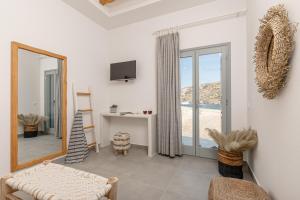 a living room with a mirror and a couch at Porto Dema Luxury Suites in Schinoussa