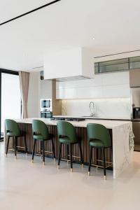a kitchen with green chairs around a kitchen counter at Luxury House Buena vista in Ica
