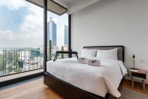 a bedroom with a large bed and a large window at Londres 256 by Wynwood House in Mexico City