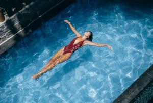 a woman swimming in a swimming pool at Pousada Pipa Soul in Pipa