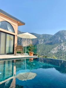 a house with a swimming pool with mountains in the background at Hestia View in Fethiye