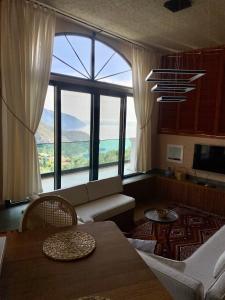 a living room with a couch and a large window at Hestia View in Fethiye