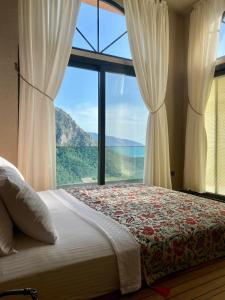 a bedroom with a bed and a large window at Hestia View in Fethiye