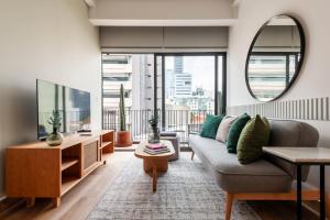 a living room with a couch and a large window at Londres 256 by Wynwood House in Mexico City