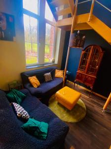 a living room with a blue couch and a window at The Séroule Park House in Verviers