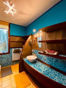 een badkamer met een wastafel en een blauwe muur bij The Séroule Park House in Verviers