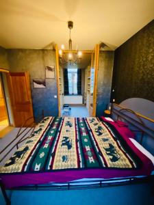 een bed in een kamer met een deken erop bij The Séroule Park House in Verviers