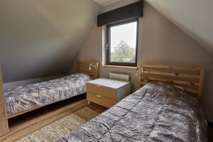 1 dormitorio en el ático con 2 camas y ventana en Bez Pośpiechu, 
