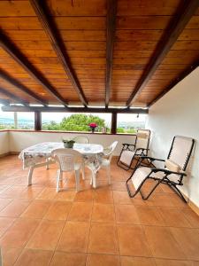 eine Terrasse mit einem Tisch und Stühlen auf einem Fliesenboden in der Unterkunft Appartamenti Castellammare del Golfo Milazzo Annarita in Castellammare del Golfo