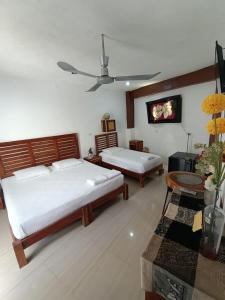 a bedroom with two beds and a tv on the wall at Casa ka'an in Isla Mujeres