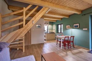 a kitchen and dining room with a wooden staircase in a house at Bez Pośpiechu in Grabowiec