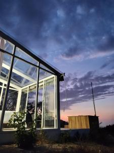a house with large glass windows with the sunset in the background at Glamping MINKAWAY in Santa Marta
