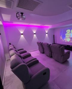 sala filmowa z fioletowymi krzesłami i ekranem w obiekcie New Serenity Art Villa Elounda w Elundzie