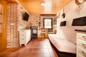 uma sala de estar com um sofá e uma parede de tijolos em Villabu VUT-LE-736 em San Emiliano