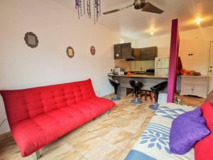 un sofá rojo en la sala de estar con cocina en Dep 304a En Casablanca Linda Suite Petfriendly cerca de todo, en Same