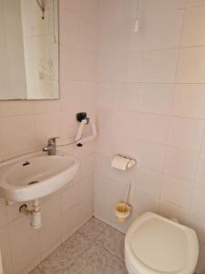 Baño blanco con aseo y lavamanos en Apartamento a un paso de playa, en Salou