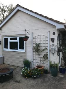 a garage with potted plants on the side of it at Annexe in lymington with private use of hot tub in Everton