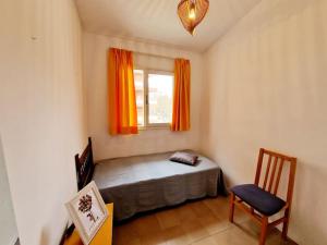 1 dormitorio con cama, ventana y silla en Apartamento a un paso de playa, en Salou