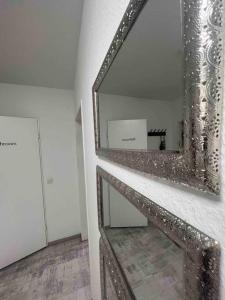 a mirror on a wall in a room at Modernes Apartment mit 75qm mit Balkon & Aussicht in Aachen