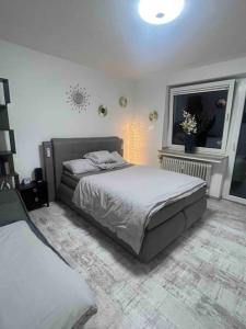 a bedroom with a large bed and a window at Modernes Apartment mit 75qm mit Balkon & Aussicht in Aachen