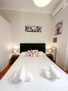 een slaapkamer met een groot wit bed en 2 stoelen bij DUOMO Dreams [Hearth Of Gallery] in Milaan