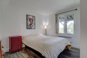 a white bedroom with a bed and a window at Eastern Township's Getaway! Beach + Ski Haven in Magog-Orford