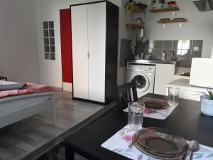 ブダペストにあるSmall studio at Corvin negyedのキッチン(ダイニングテーブル、洗濯機付)