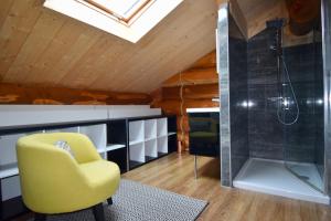 a bathroom with a yellow chair and a shower at L'Etoile du Berger in Saint-Martin-de-la-Porte