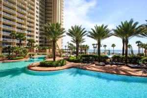 a pool at a resort with palm trees and buildings at Shores of Panama 1507 in Panama City Beach