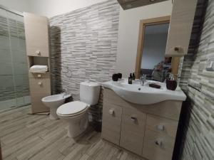 a bathroom with a sink and a toilet and a mirror at Casa Paolina in Militello in Val di Catania