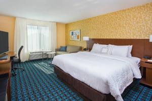 a hotel room with a large bed and a chair at Fairfield Inn & Suites by Marriott Nashville Hendersonville in Hendersonville