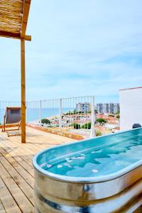 a hot tub on a deck with a view of the ocean at El Rancho at the Beach in Blanes