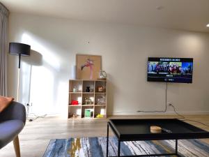 a living room with a flat screen tv on a wall at U Suites on Jessie in Wellington