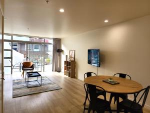 a living room with a wooden table and chairs at U Suites on Jessie in Wellington